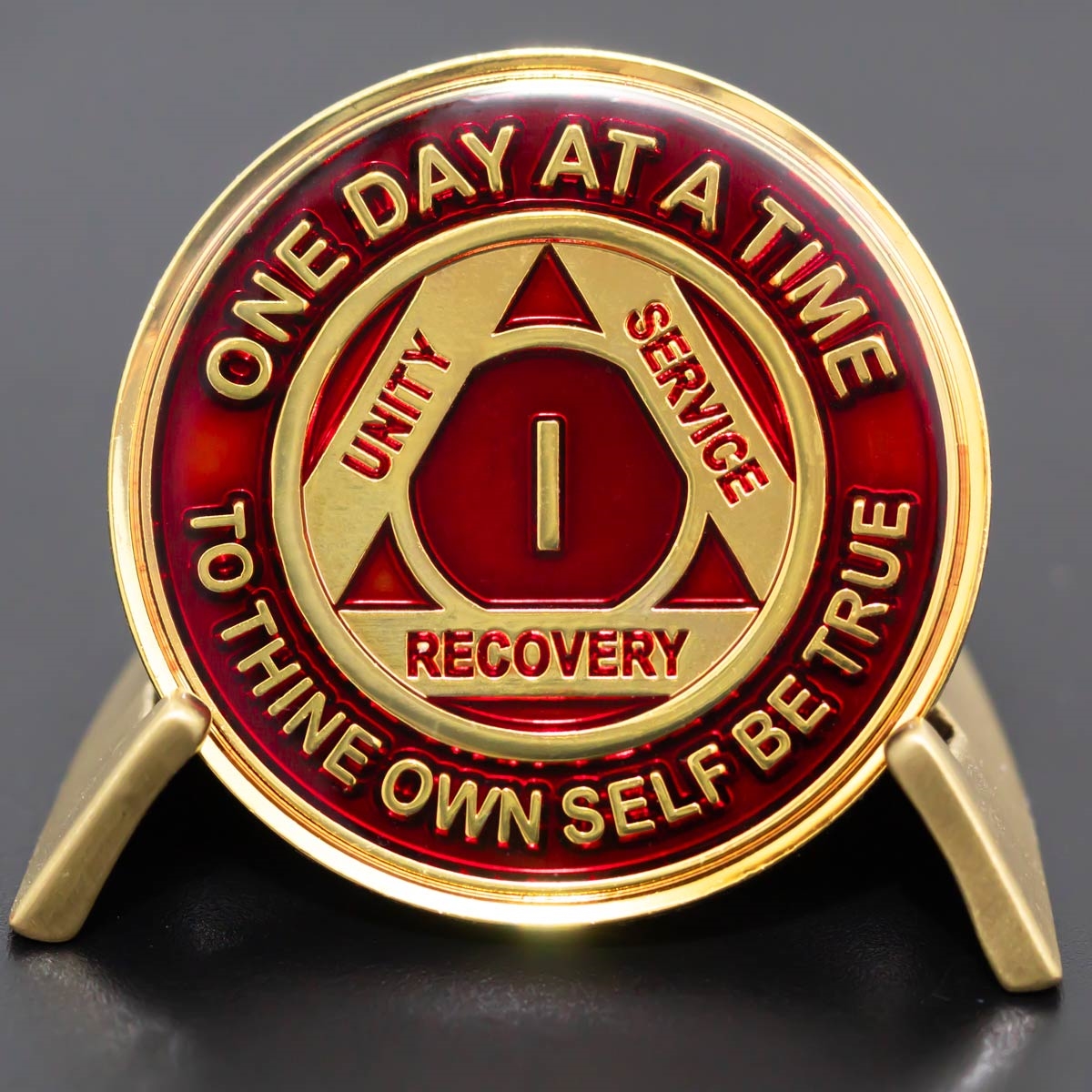 Translucent Red and Gold 1 Year AA anniversary medallion displayed on a stand
